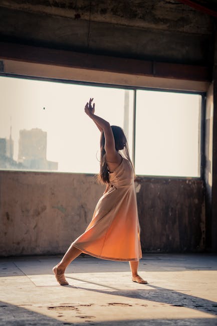 Ballet dancer performing in a rustic urban location with soft afternoon light.